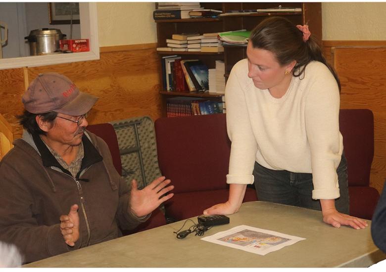WRRB Conservation Biologist Aimee Guile consults with Bobby Lafferty during a presentation on tǫdzı (boreal caribou) in Behchokǫ̀, Oct. 12.